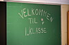 Grøn tavle med teksten «Velkommen til 1. klasse» og eit lite hjarte.